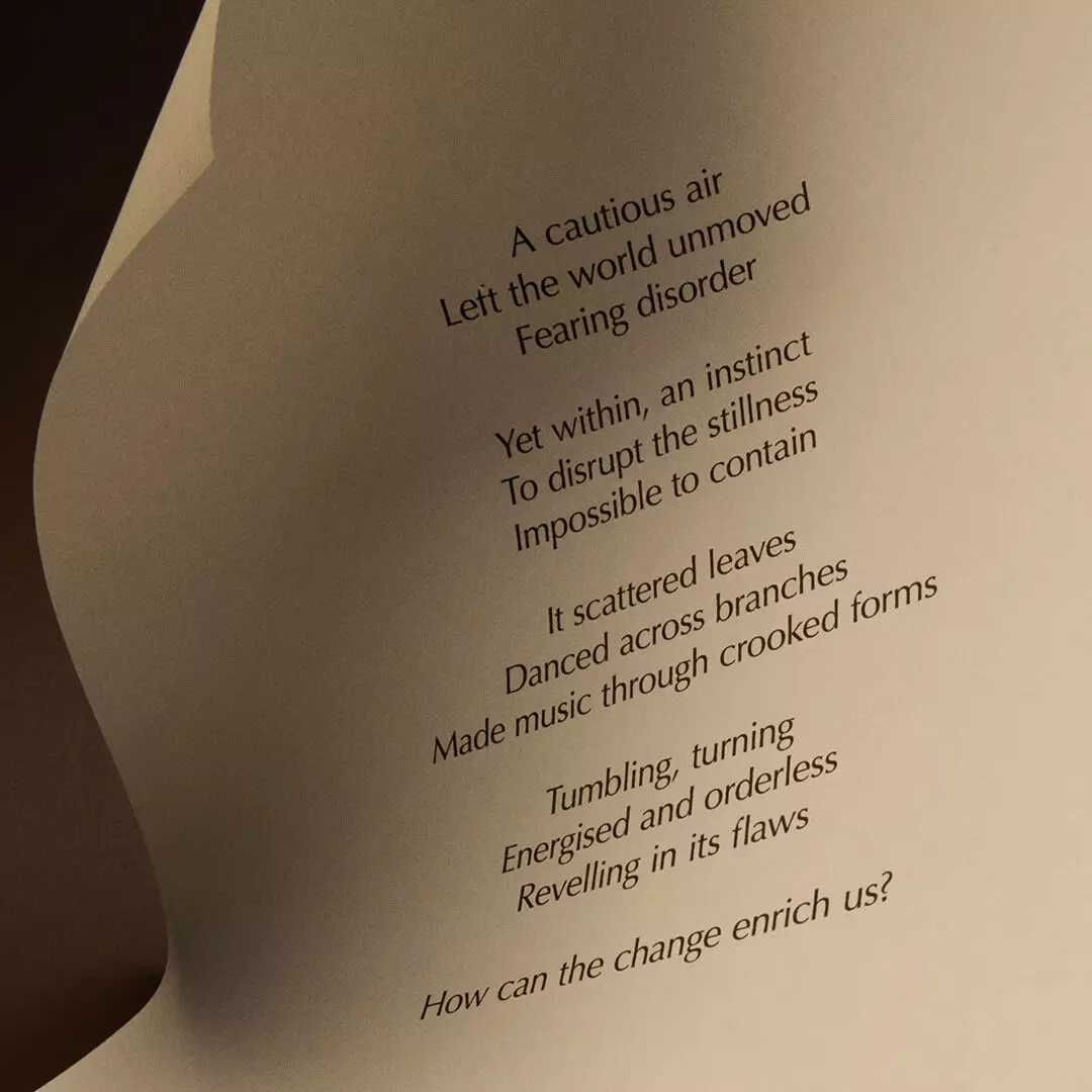 A curved cream sheet carries a printed poem about air and change, ending with the question, ‘How can the change enrich us?’
