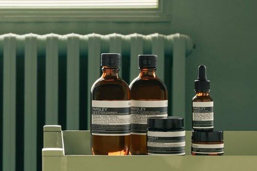 Aesop Parsley Seed product range against a sage green background