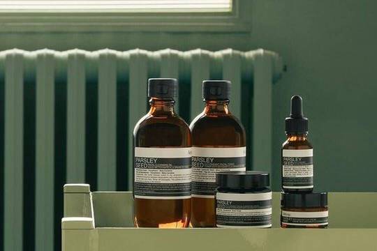 Aesop Parsley Seed product range against a sage green background
