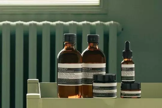 Aesop Parsley Seed product range against a sage green background
