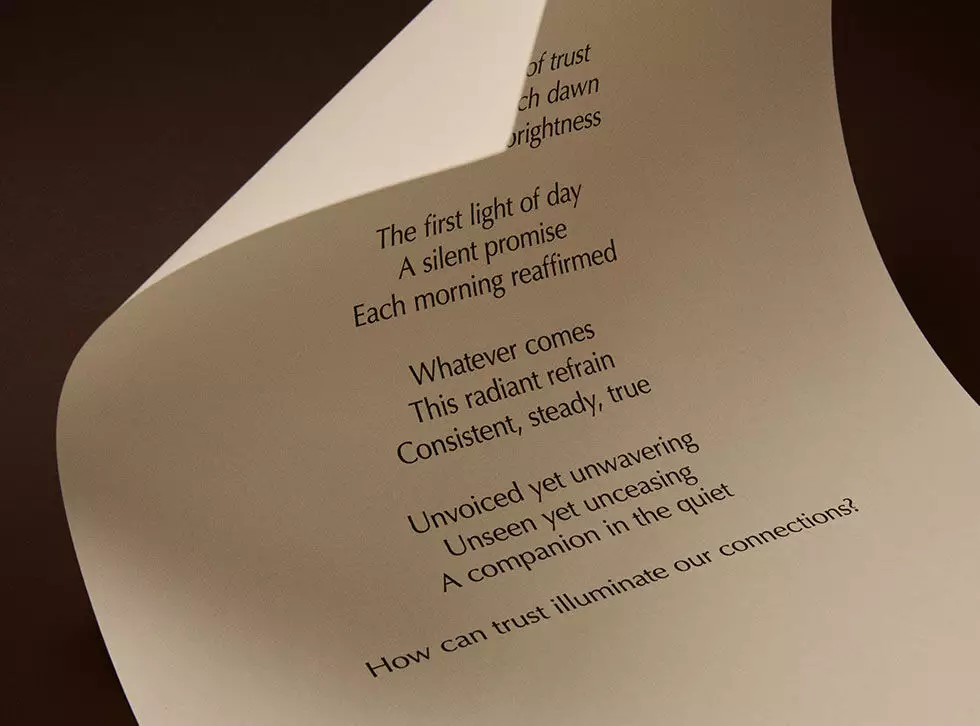 Curved cream page with printed verse against a dark brown background.
