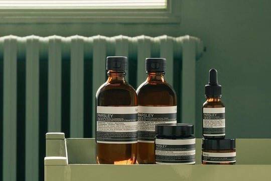 Gamme de produits Aesop Parsley Seed sur fond vert sauge