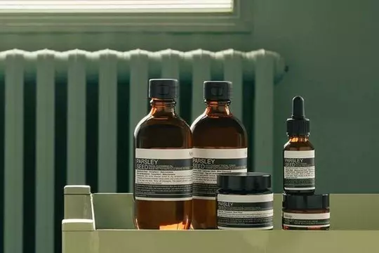 Aesop Parsley Seed product range against a sage green background