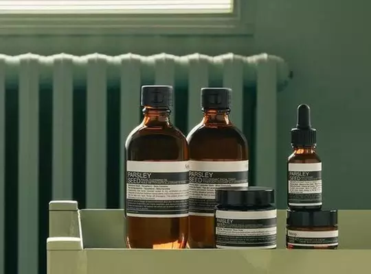 Aesop Parsley Seed product range against a sage green background