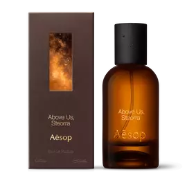 Amber glass Aesop Above Us, Steorra Eau de Parfum bottle beside its brown outer box on a white background.