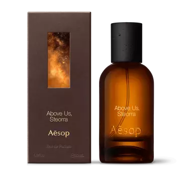 Amber glass Aesop Above Us, Steorra Eau de Parfum bottle beside its brown outer box on a white background.