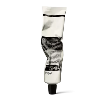 A front view of Parsley Seed Facial Cleansing Masque in an alabaster and black aluminium tube, gently crumpled from application.