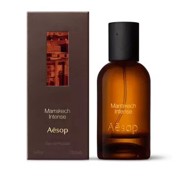 Amber glass Aesop Marrakech Intense Eau de Parfum bottle beside its brown outer box on a white background.