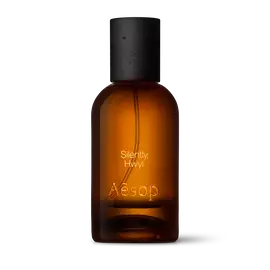 Amber glass Aesop Silently Hwyl Eau de Parfum bottle with black cap on a white background.