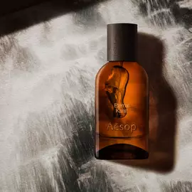 Aesop Eternal Karst bottle on a foamy white surface.