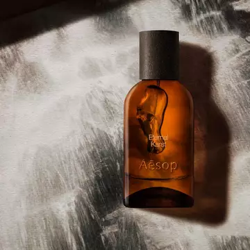 Aesop Eternal Karst bottle on a foamy white surface.