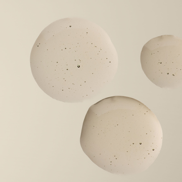 Gouttes de la texture d'Aesop Gouttes Anti-Odeur de Merde sur une surface pale.
