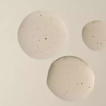 Gouttes de la texture d'Aesop Gouttes Anti-Odeur de Merde sur une surface pale.